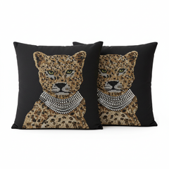Two decorative pillows with leopard designs and beaded necklaces on a black background.