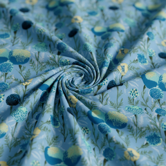 Roll of floral fabric with blue and green flowers on a light blue background