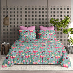 Floral patterned bedspread on a bed with a geometric wall design in the background.