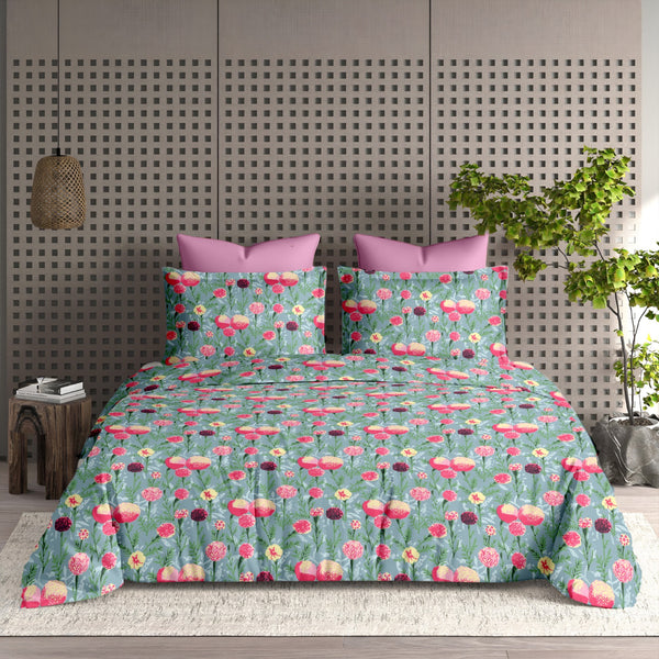 Floral patterned bedspread on a bed with a geometric wall design in the background.