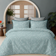 Teal floral patterned bedding set on a bed with a wooden headboard and side table.