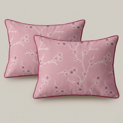 Two pink pillows with floral patterns on a light gray background