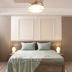 Modern bedroom with wooden headboard, light green bedding, and ceiling light fixture.