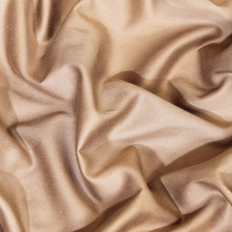 Close-up of beige satin fabric with folds