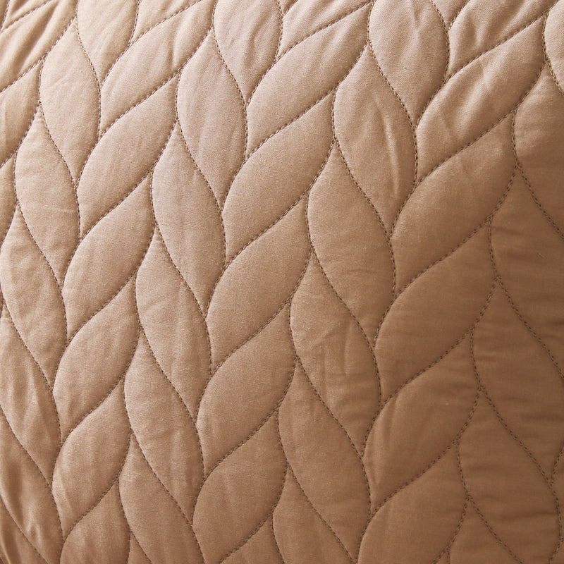 Close-up of a quilted beige fabric with a diamond pattern