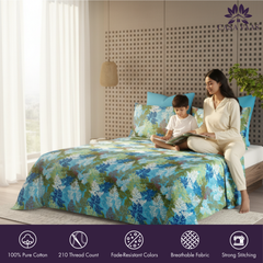 Woman and child sitting on a bed with floral bedding, surrounded by natural light.