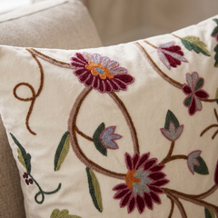 Decorative pillow with floral embroidery on a beige background