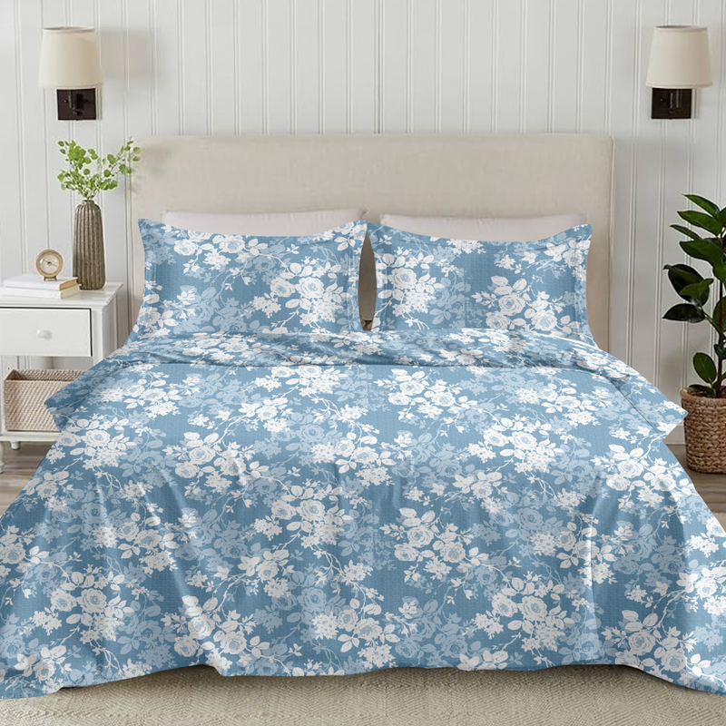 Blue floral bedding set on a bed with matching pillows in a bedroom setting.