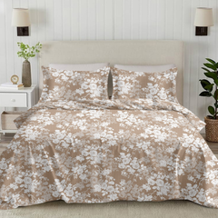 Floral duvet set on a bed in a bedroom with lamps and plants.