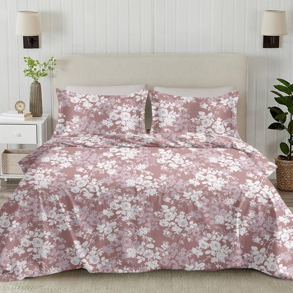 Floral bedding set on a bed in a bedroom with lamps and plants.