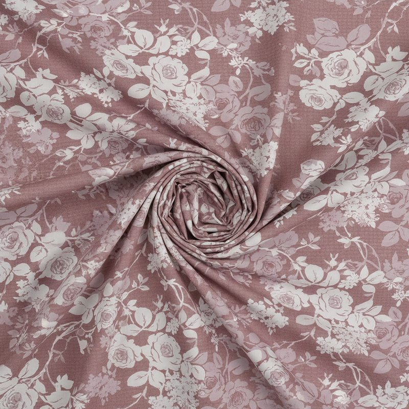 Roll of pink floral fabric with white flowers
