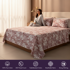 Woman sitting on a bed with floral bedding in a bedroom setting