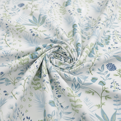 Roll of fabric with blue and green floral pattern on white background
