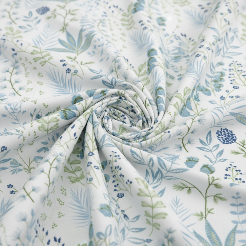 Roll of fabric with blue and green floral pattern on white background