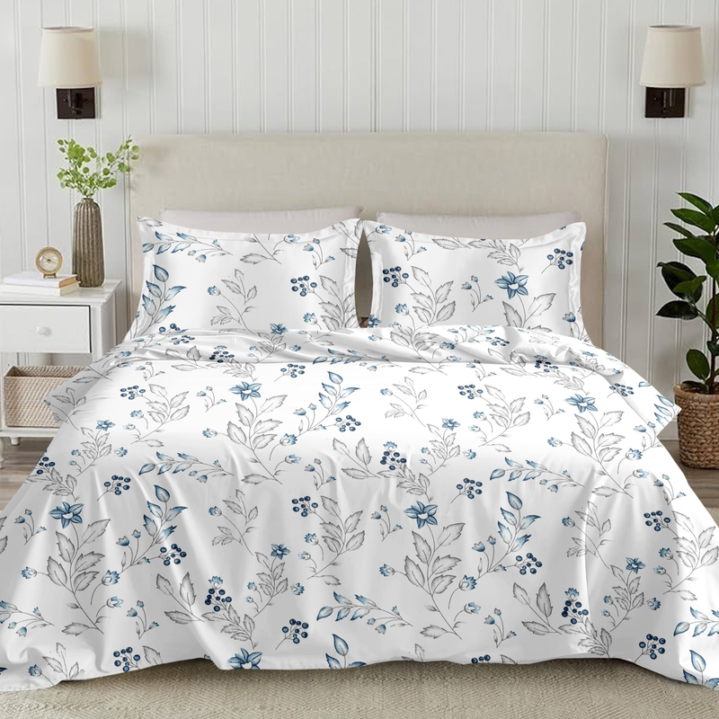 Floral-patterned bedding set on a bed in a bedroom setting with plants and lamps.