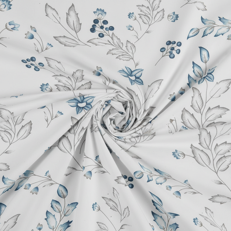 Floral fabric pattern with blue flowers and green leaves on a white background