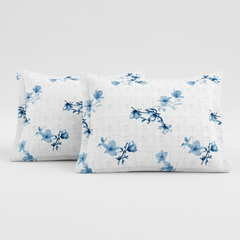 Two white pillows with blue floral patterns on a light gray background
