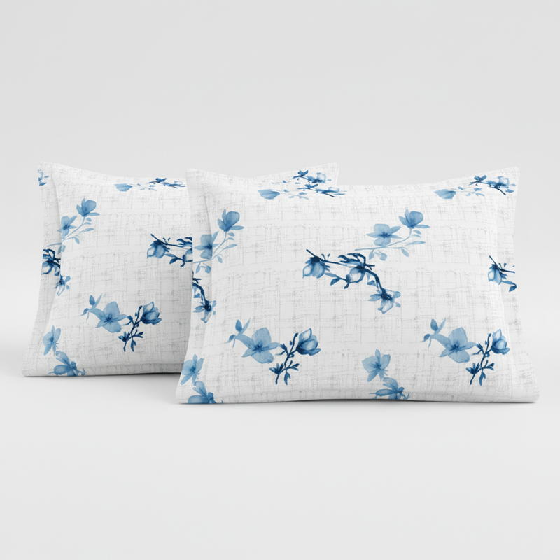 Two white pillows with blue floral patterns on a light gray background
