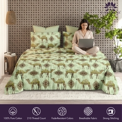 Woman using a laptop on a bed with a camel patterned comforter, featuring the brand 'Ombre'.
