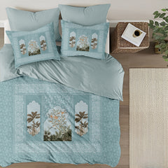 Teal bedding set with floral embroidery on a bed in a bedroom setting.