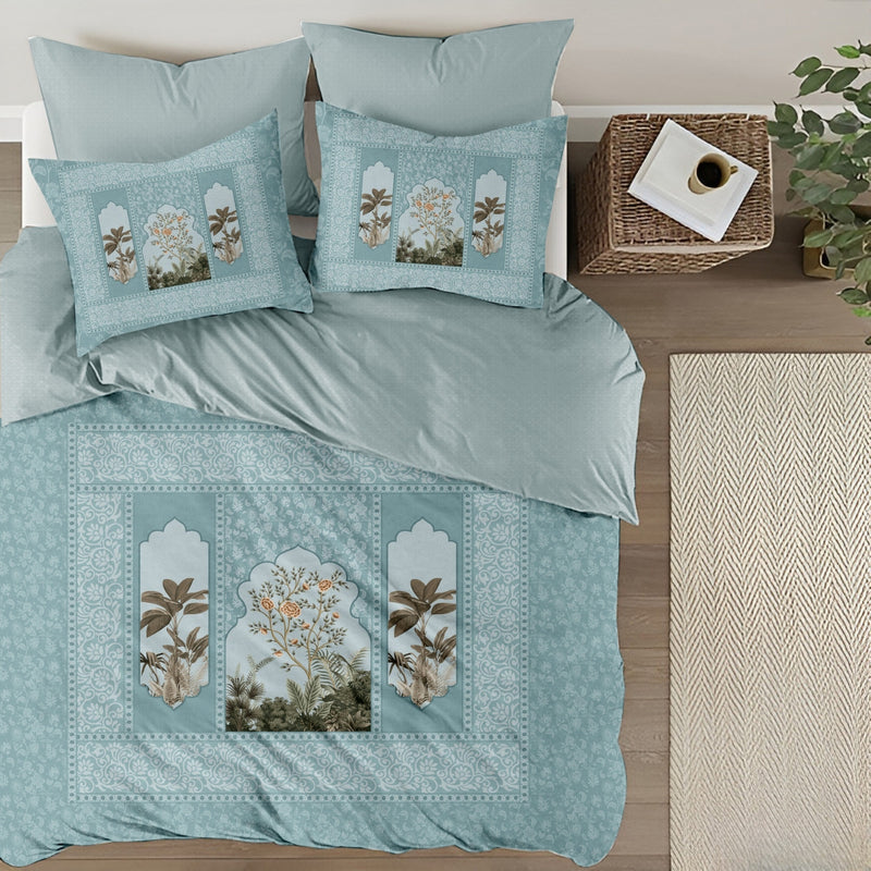Teal bedding set with floral embroidery on a bed in a bedroom setting.
