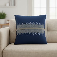 Navy blue pillow with decorative pattern on a beige sofa in a living room setting.
