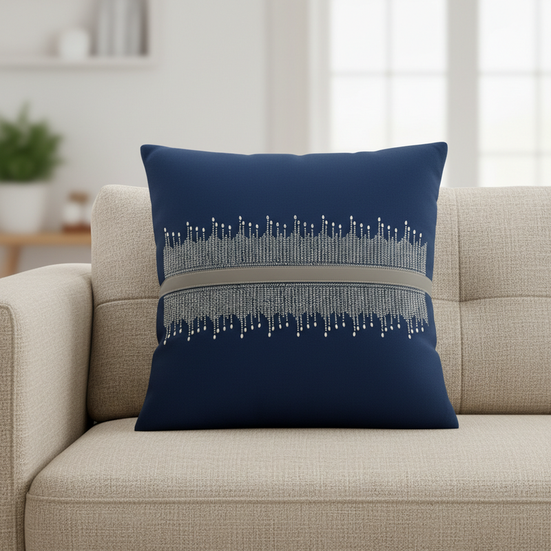 Navy blue pillow with decorative pattern on a beige sofa in a living room setting.