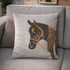 Decorative pillow with horse design on a gray sofa