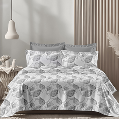 Gray and white leaf-patterned bedding set on a bed in a bedroom.