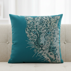Teal pillow with leopard design on a beige sofa